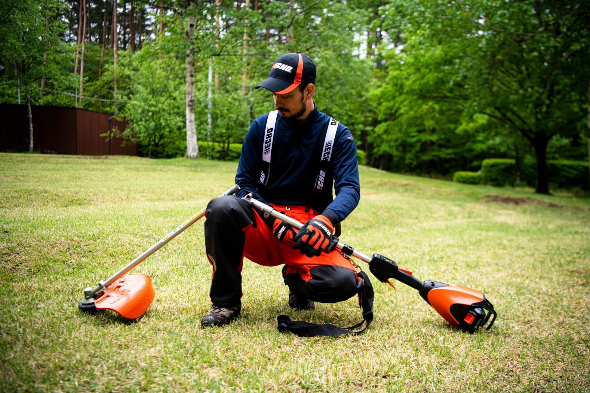 3ue5lwtuckk.jpg - Mowers Online Man with cordless lawn care tools in yard