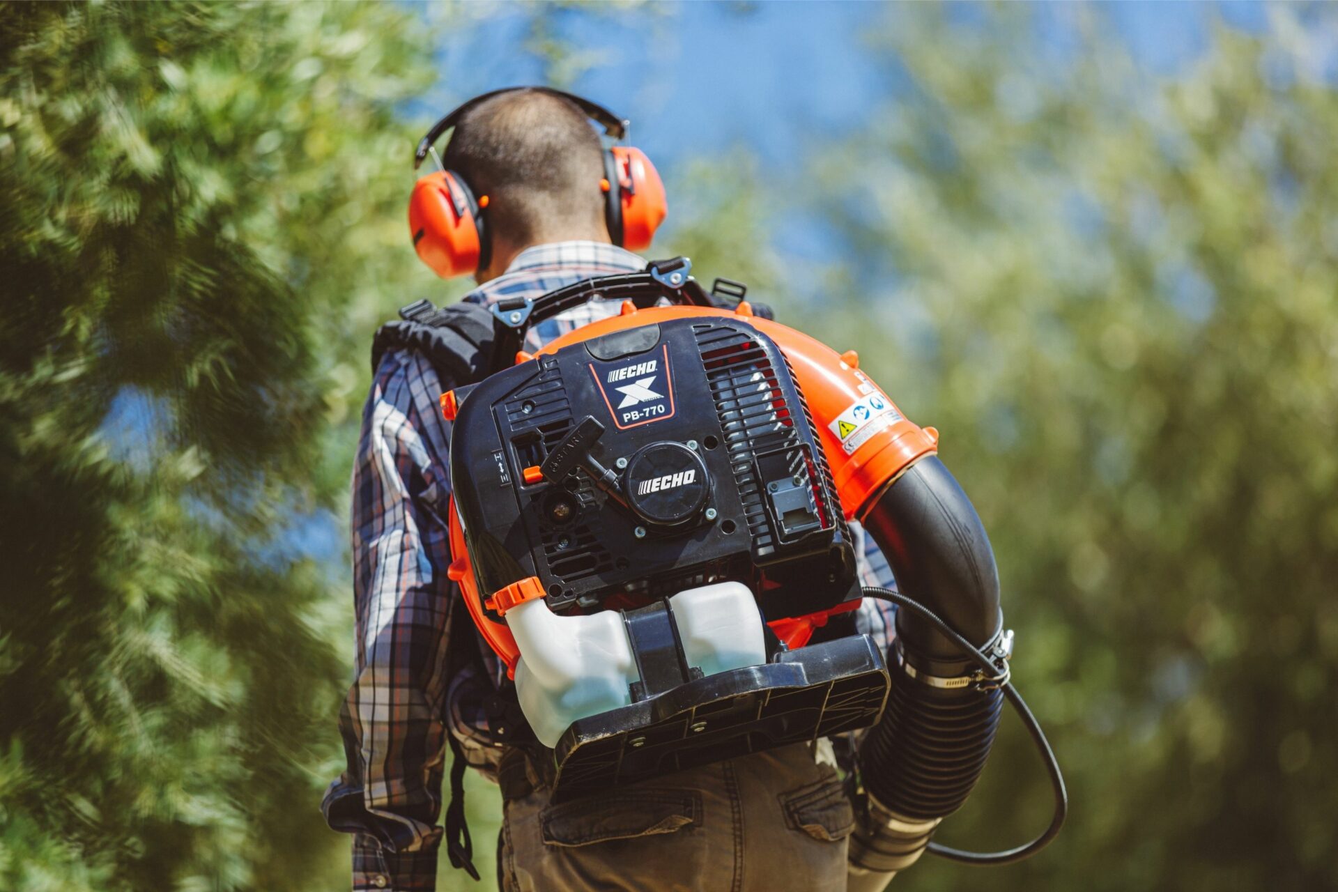 4g2chbrz25o.jpg - Mowers Online Worker wearing backpack and ear protection outdoors